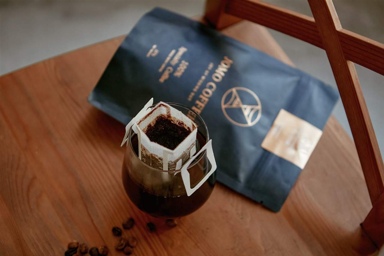 掛耳咖啡與深藍 JOMO COFFEE 包裝置於木椅上